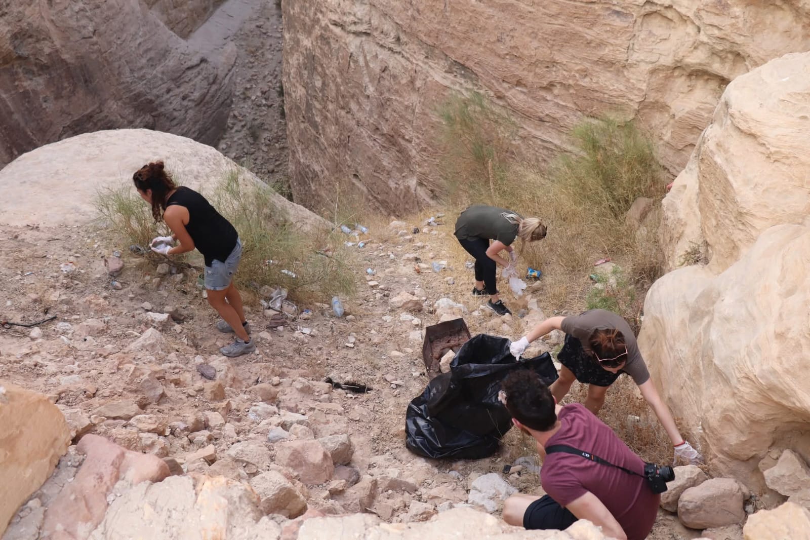 Guests picking up plastic in a Petra canyon