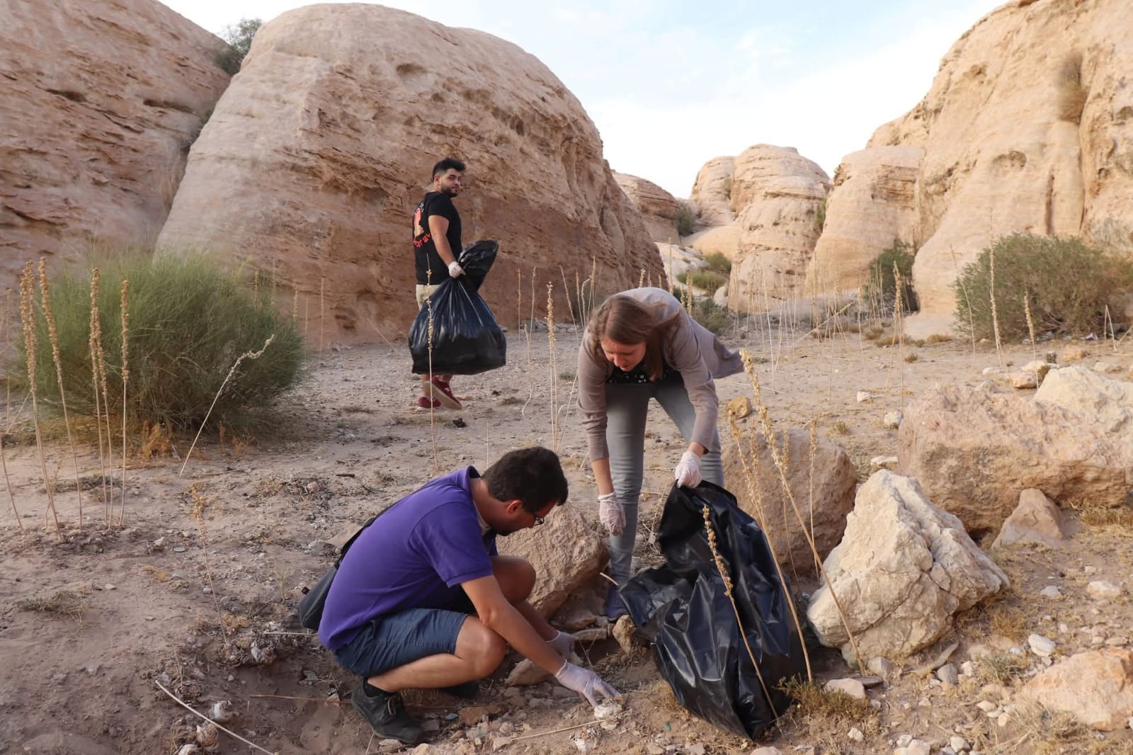 Volunteers collecting waste among the rocks