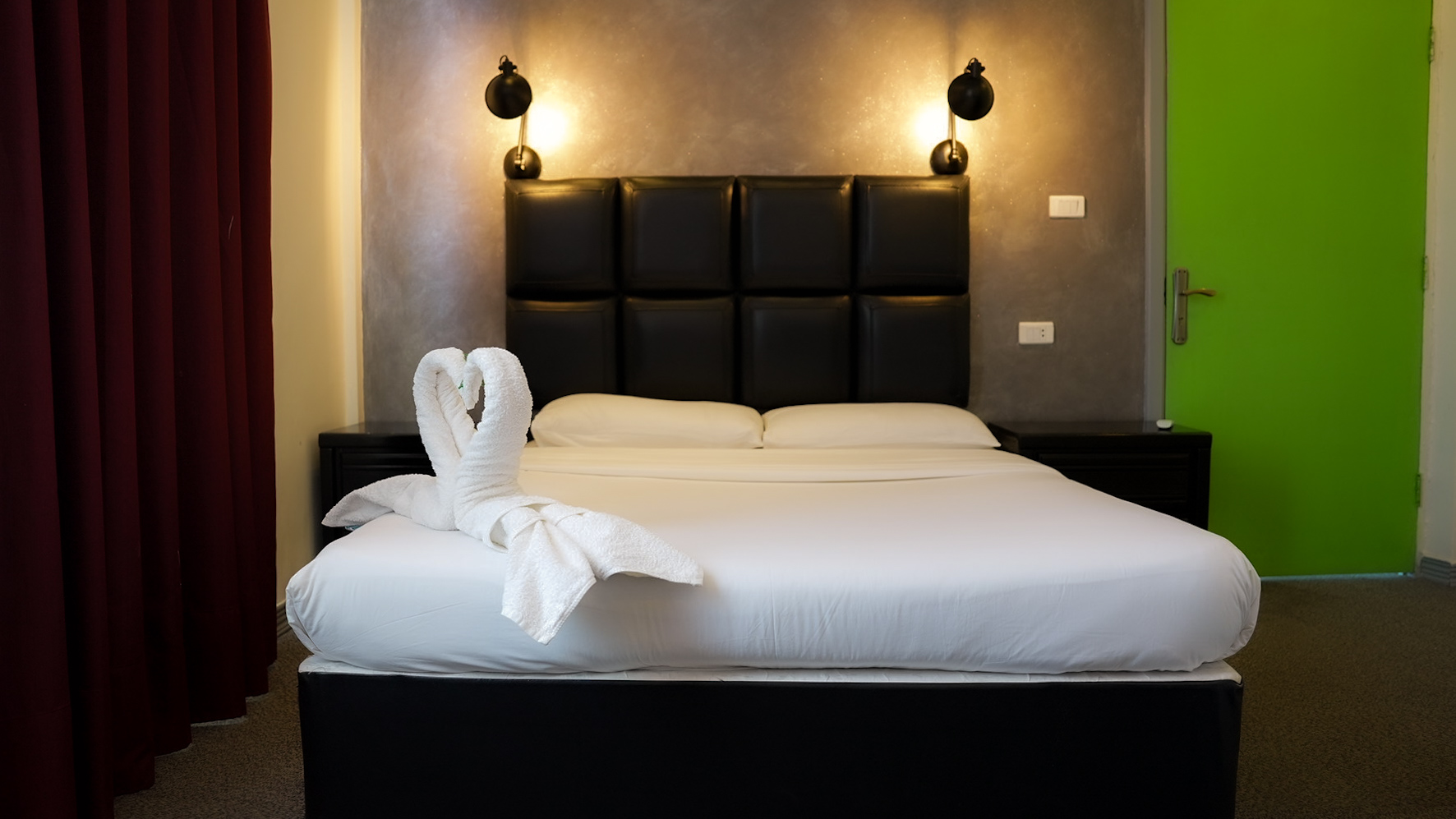 Private double room with leather headboard and dark feature wall