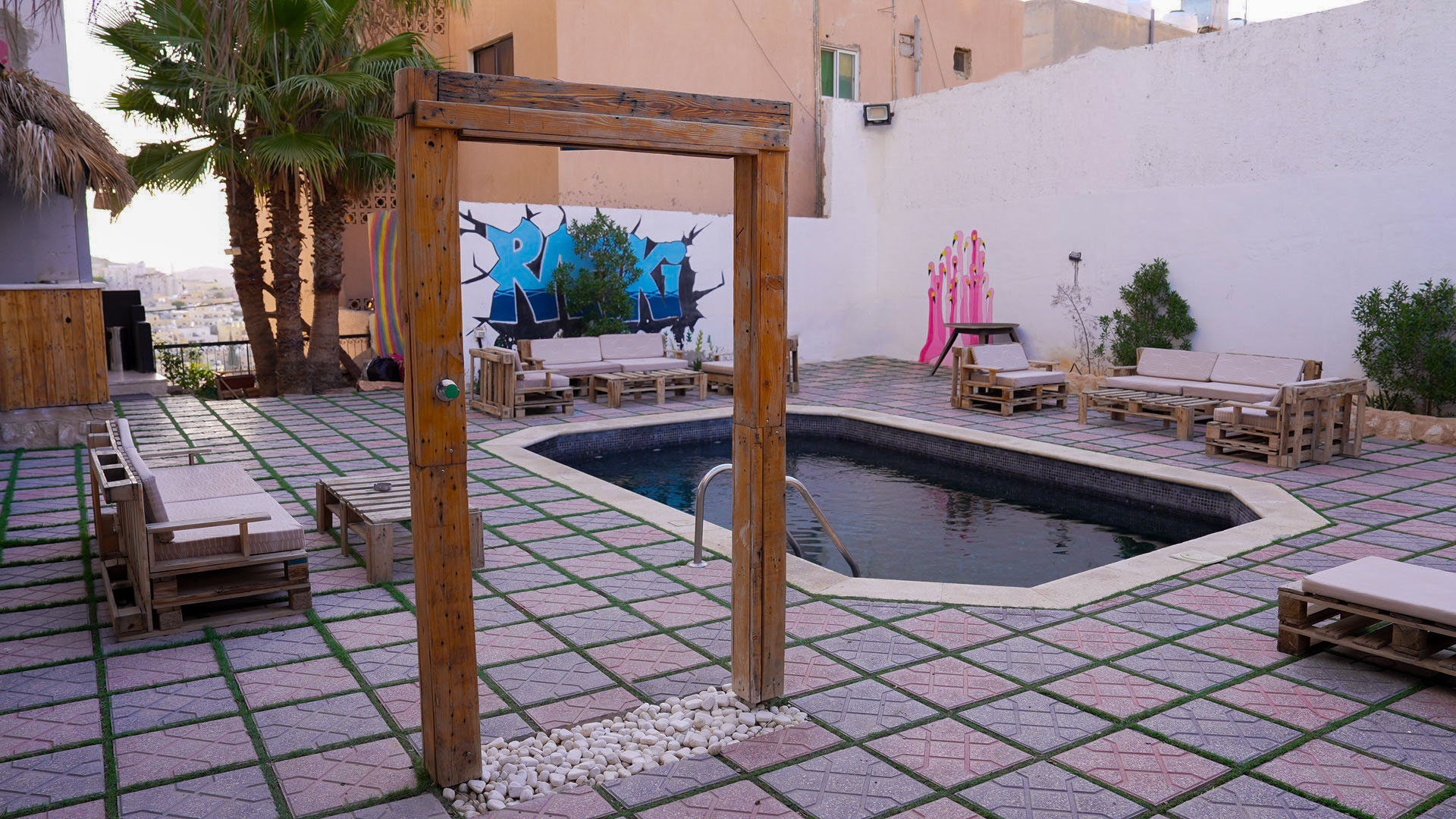Pool courtyard with Rafiki graffiti and palm trees